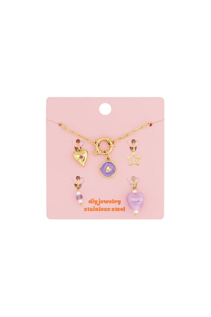 Gold-tone stainless steel modular charm bracelet kit with heart, star, and purple enamel charms on a pink display card.