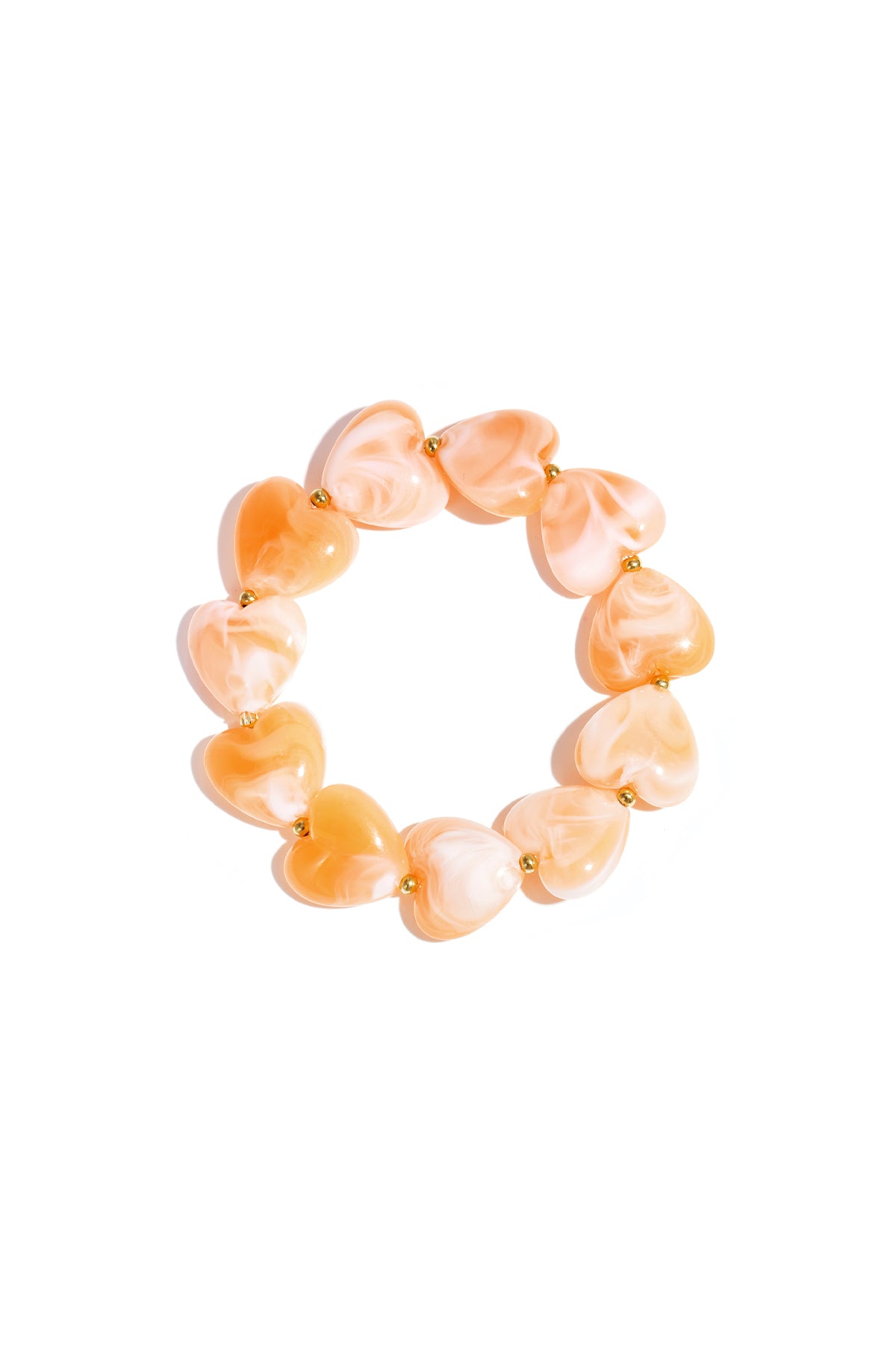 Stretch bracelet with peach marble-effect resin heart beads and small gold spacer beads, on a white background.