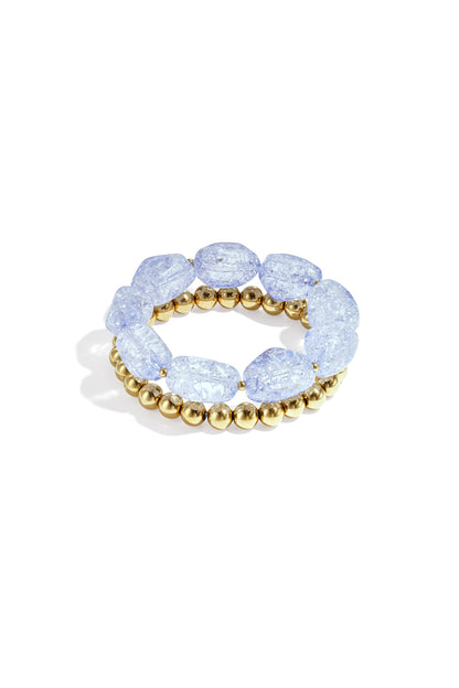 Close-up of light blue chunky beaded bracelet set with crackled acrylic beads and gold-tone beads on white background