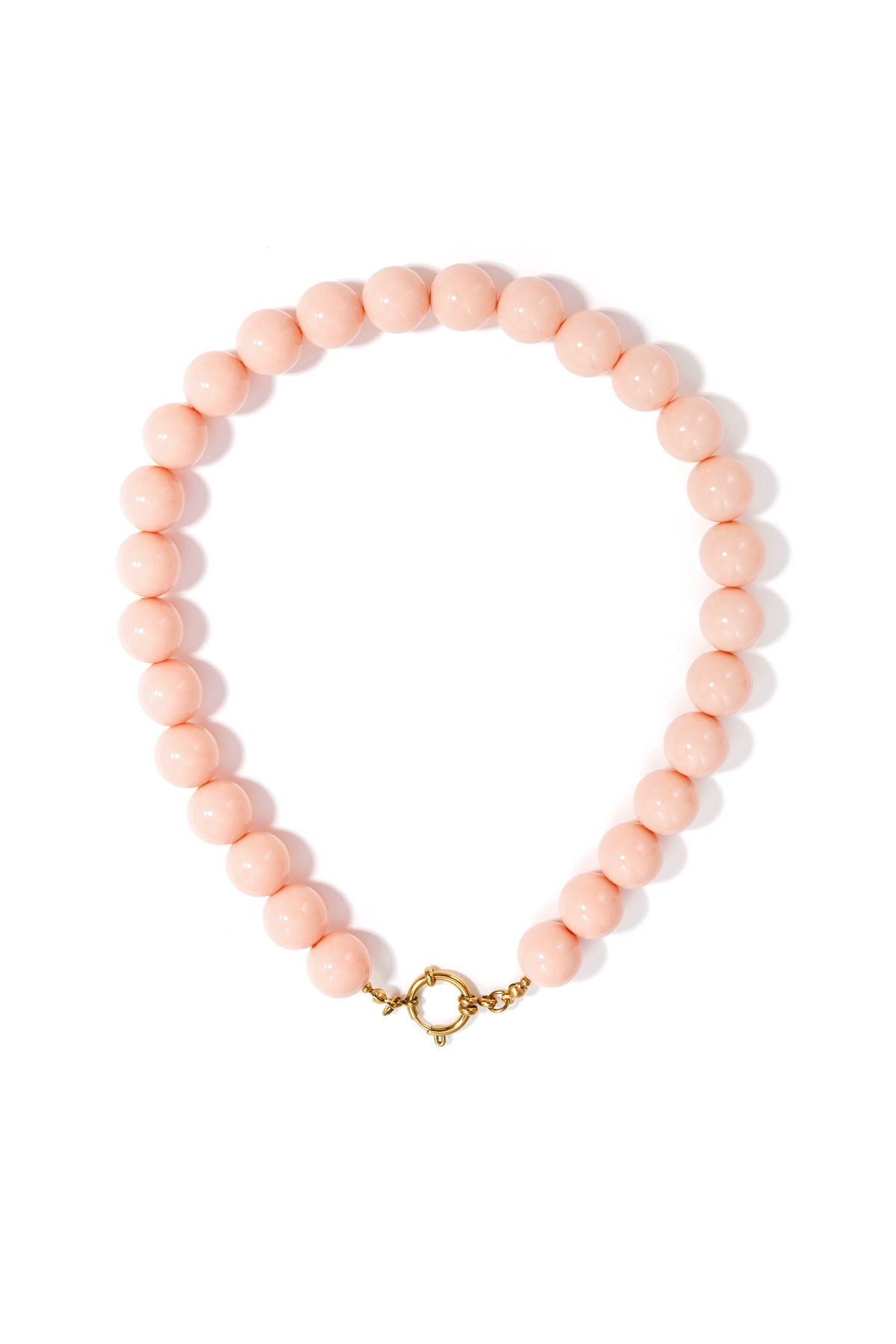 Chunky necklace of smooth, pale pink resin beads with a round gold front-clasp closure on a white background.