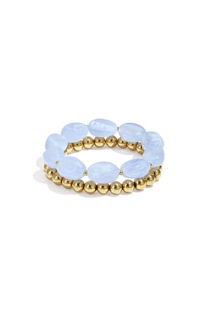 Close-up of two beaded stretch bracelets featuring oval lavender resin beads and gold-tone round beads on white background