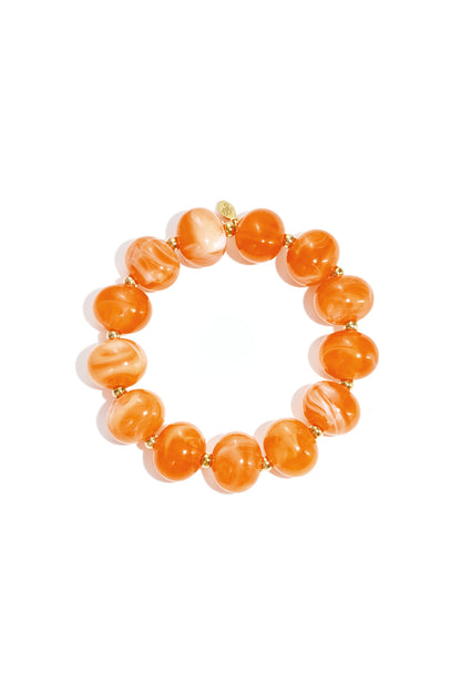 Apricot orange marbled beaded stretch bracelet with gold accent beads on white background