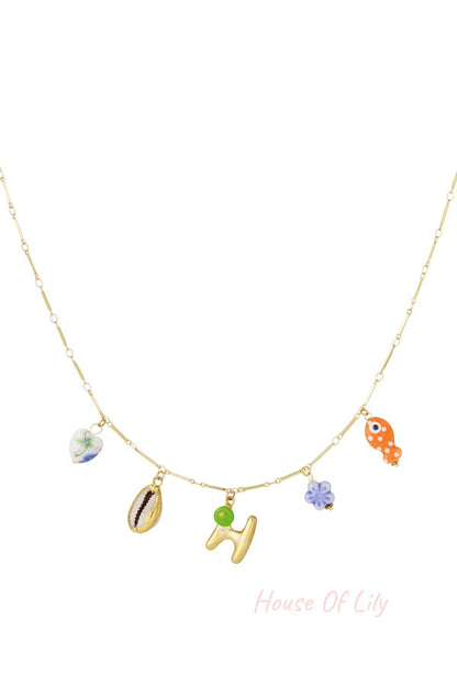 Main Character Initial gold chain necklace with colorful charms: heart, shell, initial H, purple flower, and orange fish.
