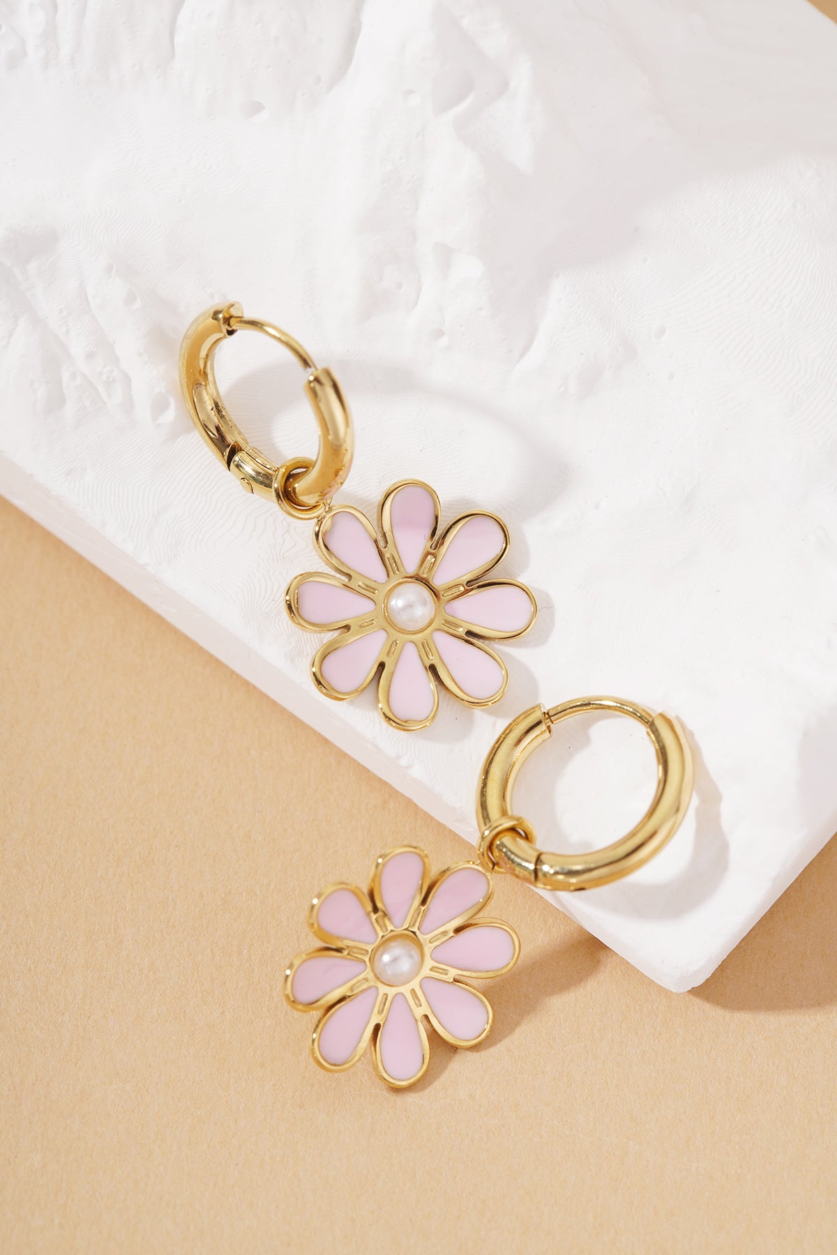 Golden Bloom Hoops: Gold hoop earrings featuring a pink daisy flower charm with a small white pearl center.
