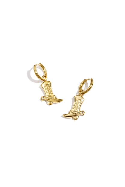 Pair of gold cowboy boot charm drop earrings with rhinestone detail on white background