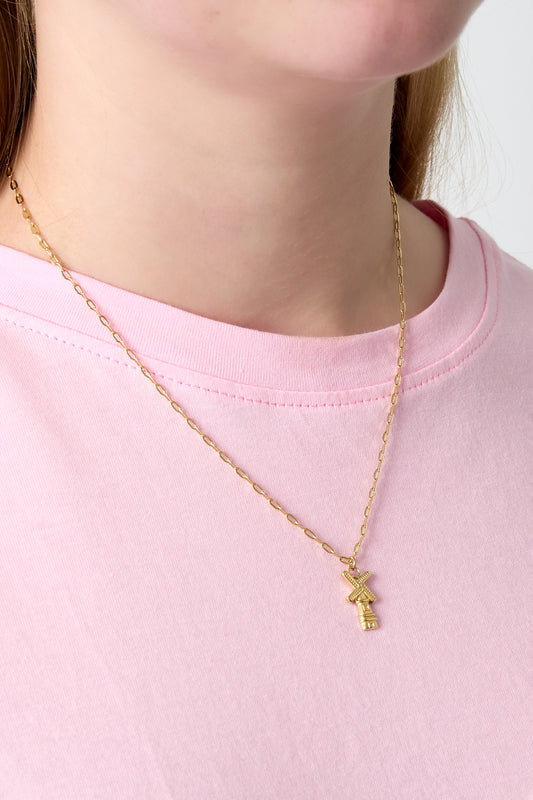 Close-up of a woman wearing the gold Dutch Breeze windmill charm necklace with a pink shirt