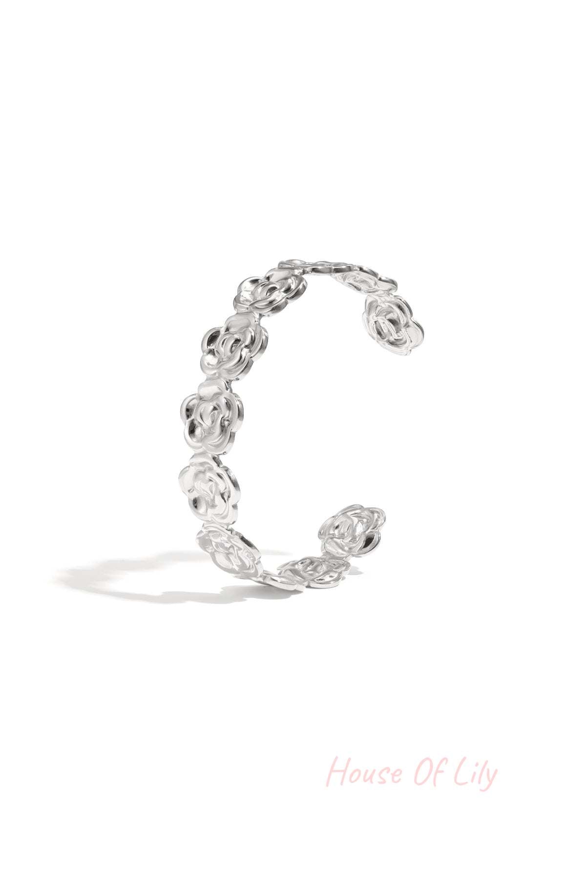 Silver floral cuff bracelet with flower-shaped links displayed on white background