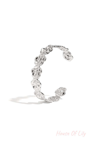 Silver floral cuff bracelet with flower-shaped links displayed on white background