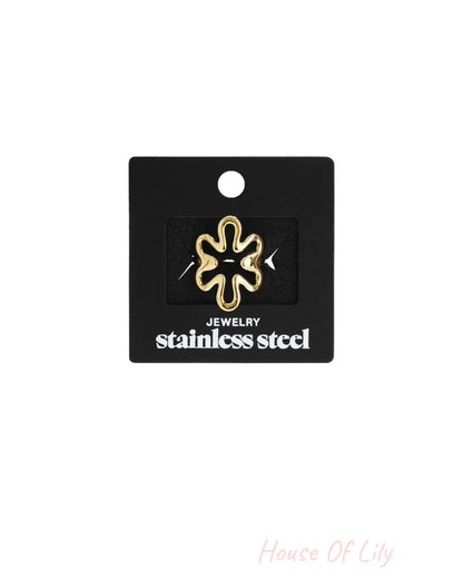 Gold-toned stainless steel flower ring pinned on a black card.