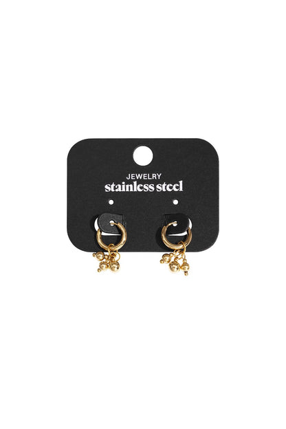 Gold stainless steel hoop earrings with hanging bead charms on a black display card.