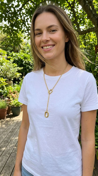 Model wearing the Golden Y Vibe necklace with a white tee outdoors, emphasizing its length, movement, and stylish design in natural daylight.