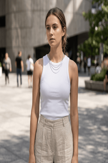 Full-length view of a model wearing a layered gold chain necklace styled with casual outfit in an urban setting, showcasing its versatile length and trendy appeal.