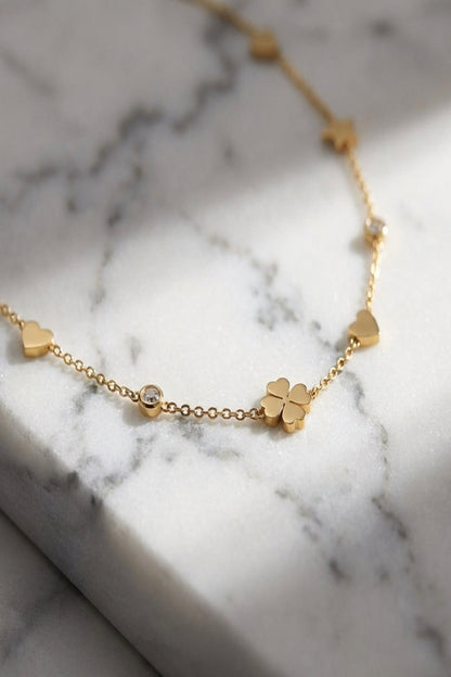 Close-up of the Gleaming Wish Star Necklace with tiny reflective discs on textured white marble, highlighting fine links and mirror-like finish.