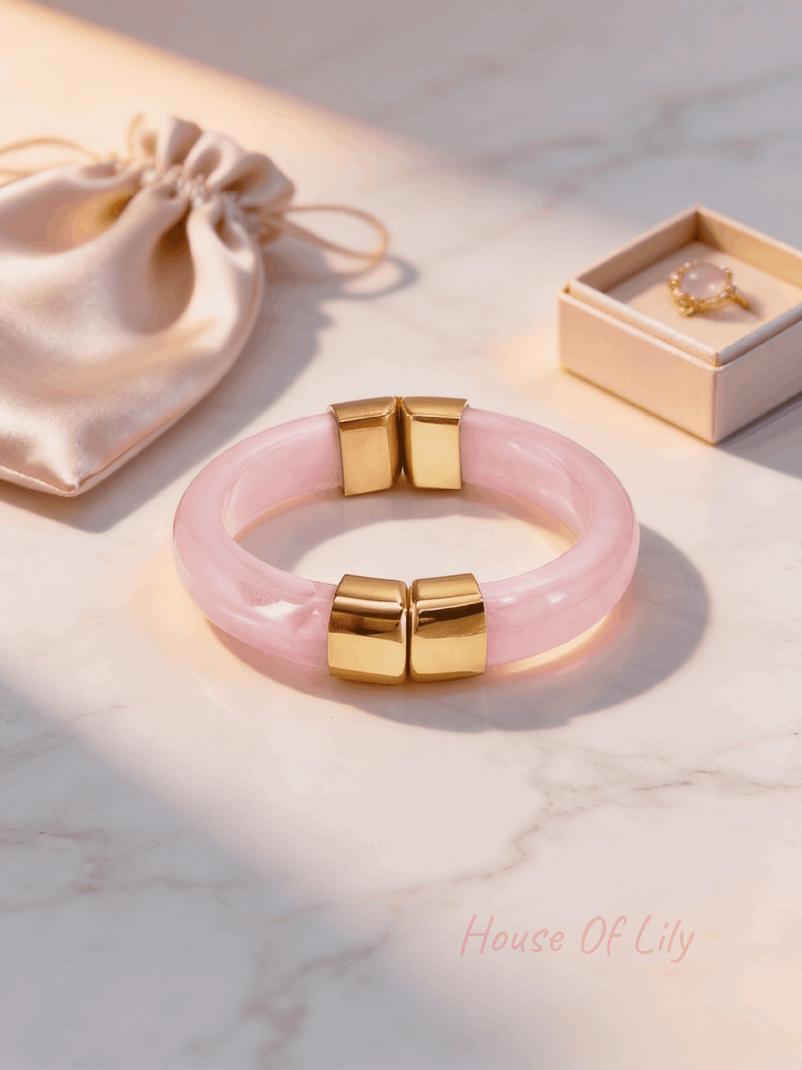 Golden Hour Bangle: A glossy, pale pink translucent resin bangle accented with two polished gold-tone metal segments.