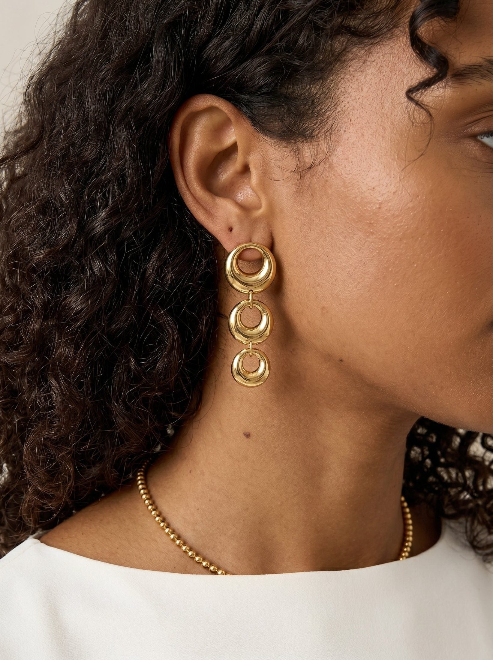Main Character Hoops: Gold drop earrings featuring three graduated, polished, circular linked rings.
