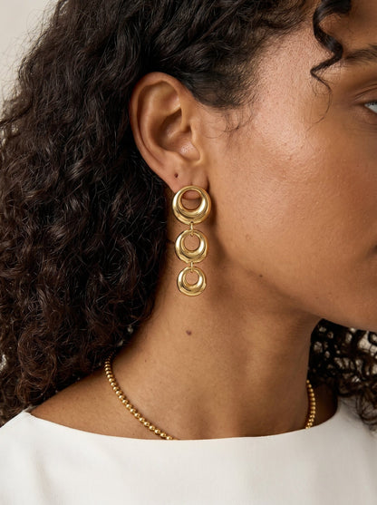 Main Character Hoops: Gold drop earrings featuring three graduated, polished, circular linked rings.