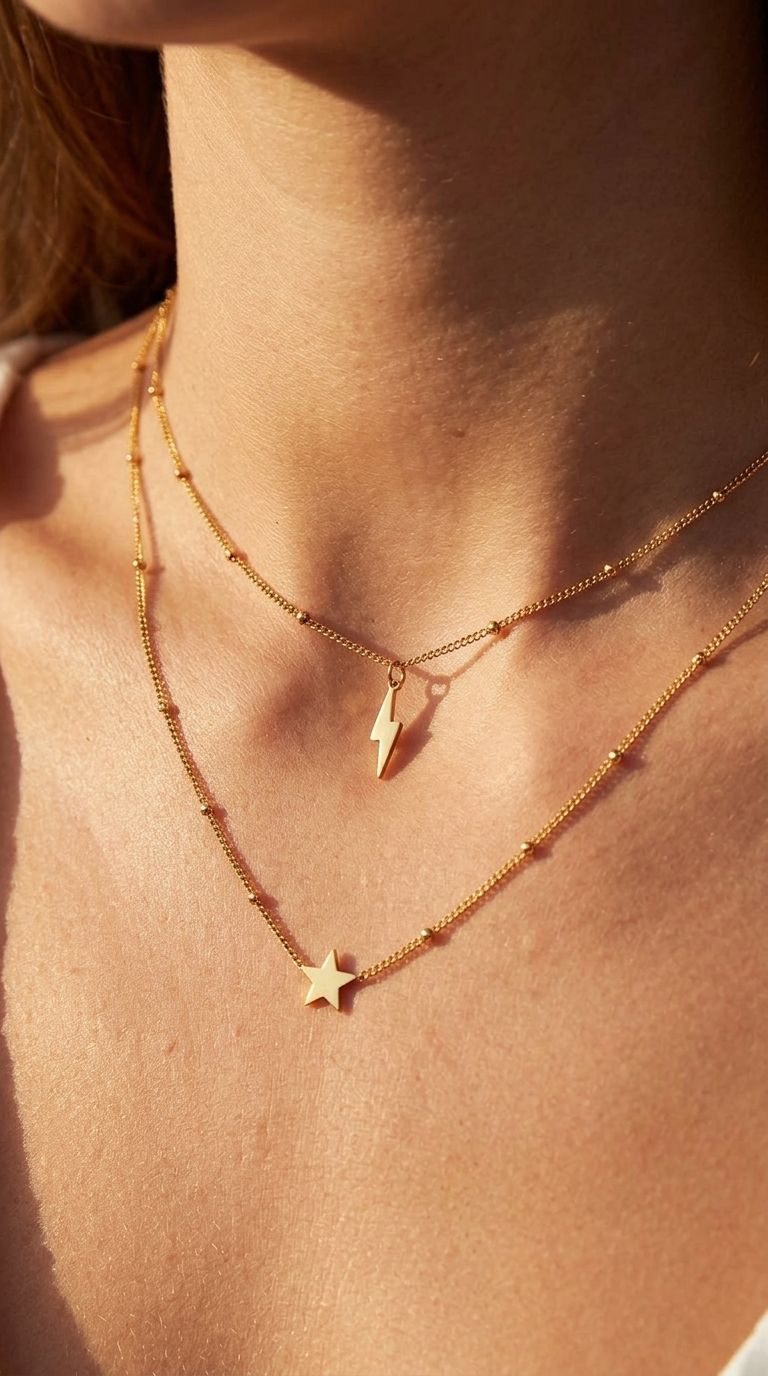 Lightning bolt pendant necklace on wood surface showing sleek stainless steel design and lobster clasp detail.