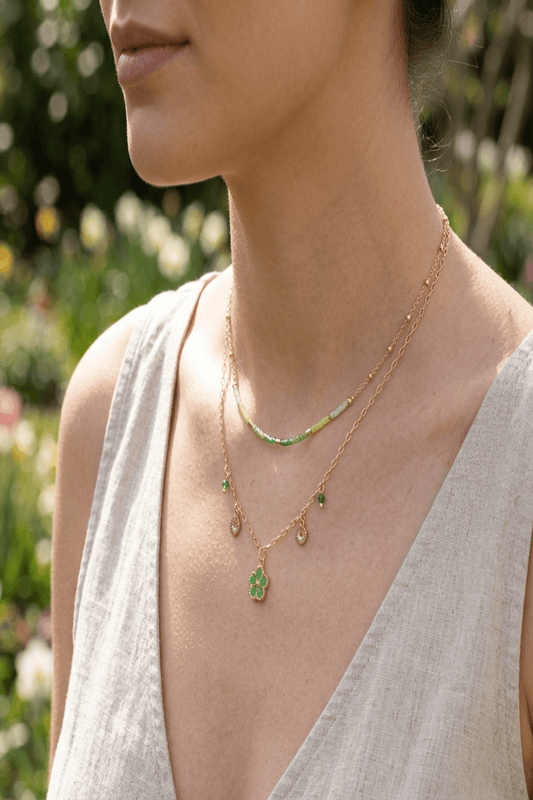 Fashion model wearing the playful layered flower necklace outdoors, showcasing its layered structure and spring-themed setting with greenery.