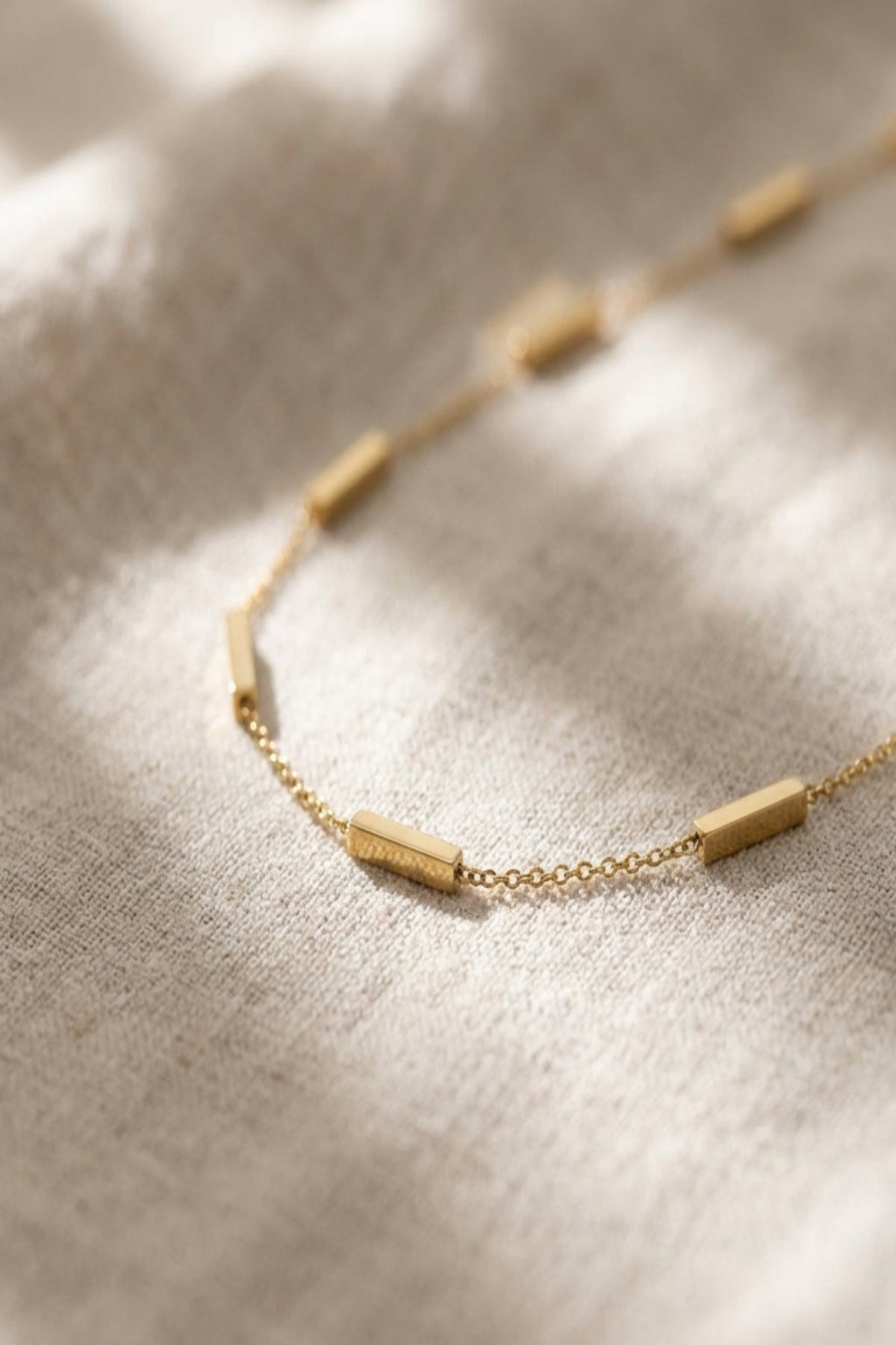 Close-up of a delicate stainless steel bar pendant necklace with subtle pattern and fine craftsmanship, ideal for modern trendy jewelry enthusiasts.