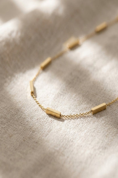 Close-up of a delicate stainless steel bar pendant necklace with subtle pattern and fine craftsmanship, ideal for modern trendy jewelry enthusiasts.