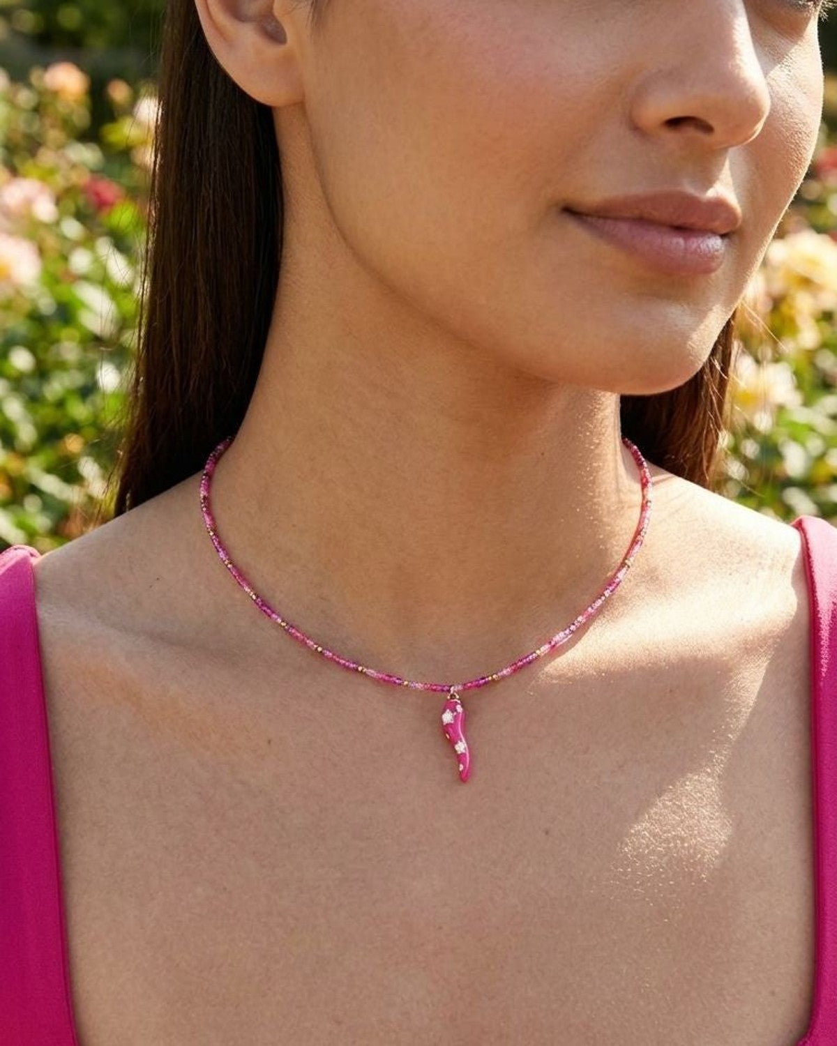 Close-up of Playful Pepper Beaded necklace on a female model, showcasing colorful beads catching sunlight with a collarbone-length fit.