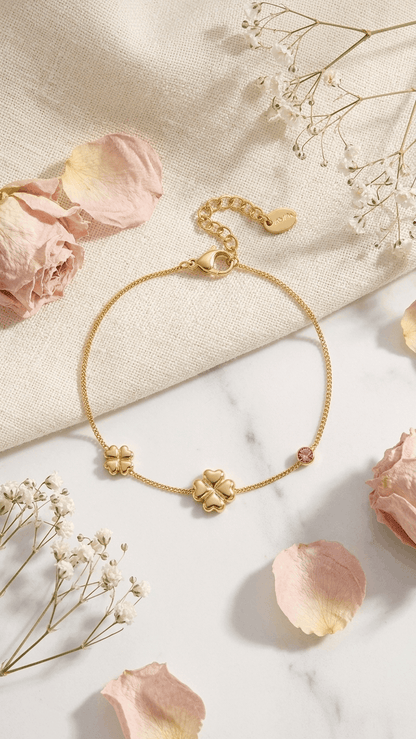 Gold chain Lucky Clover Charm Bracelet featuring two clover charms and a small pink crystal stone.
