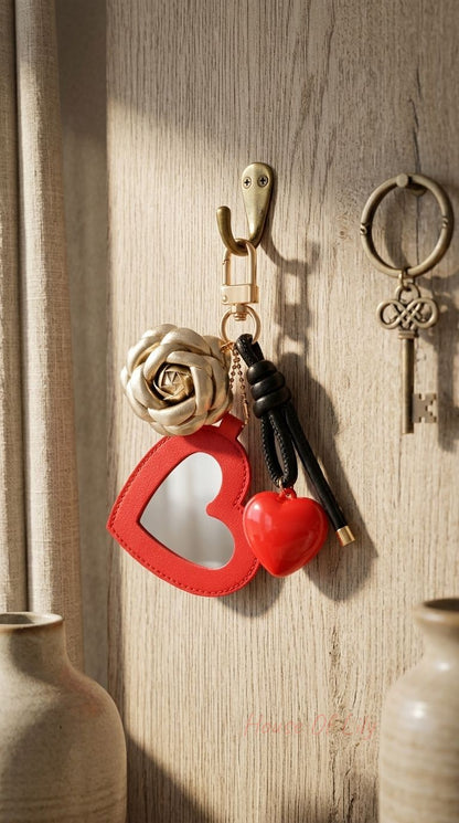 Heart & Rose keychain with glossy heart mirror, gold rose pendant, black braided strap on vintage wooden or fabric background.
