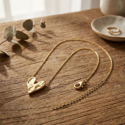 Love Struck Chain necklace displayed on a rustic wooden surface, emphasizing craftsmanship and adjustable extension in natural light.