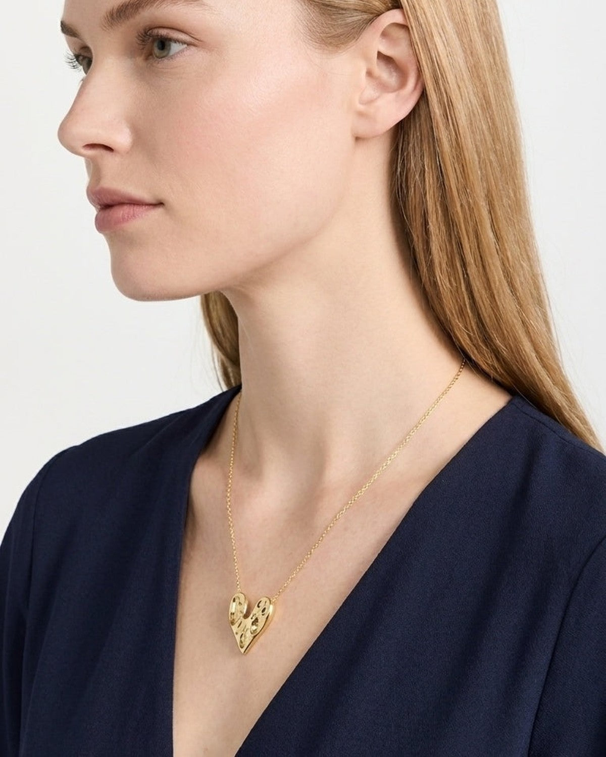 House Of Lily's gold-plated Love Struck Chain necklace with a textured heart pendant on a woman.