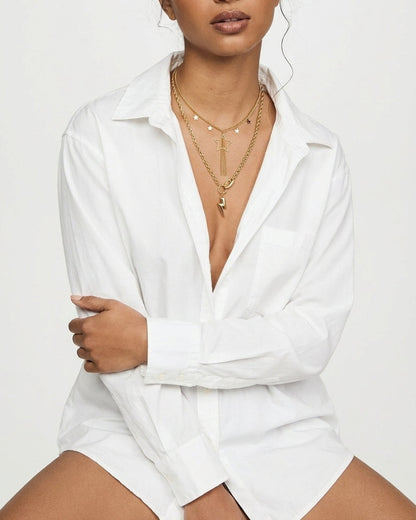 Layered gold tone pendant necklaces with star and lightning bolt charms worn on a model.