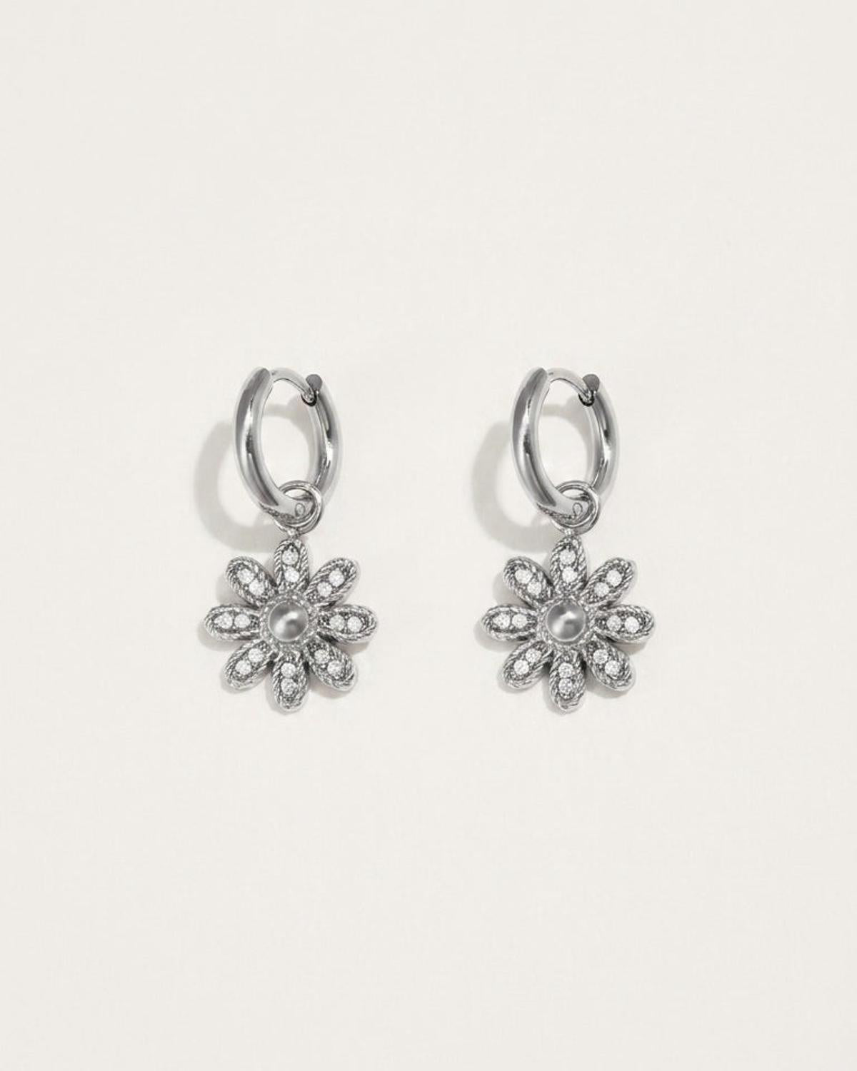 Silver flower drop earrings with small hoop tops and pavé-set crystal petals around a central metal dome.