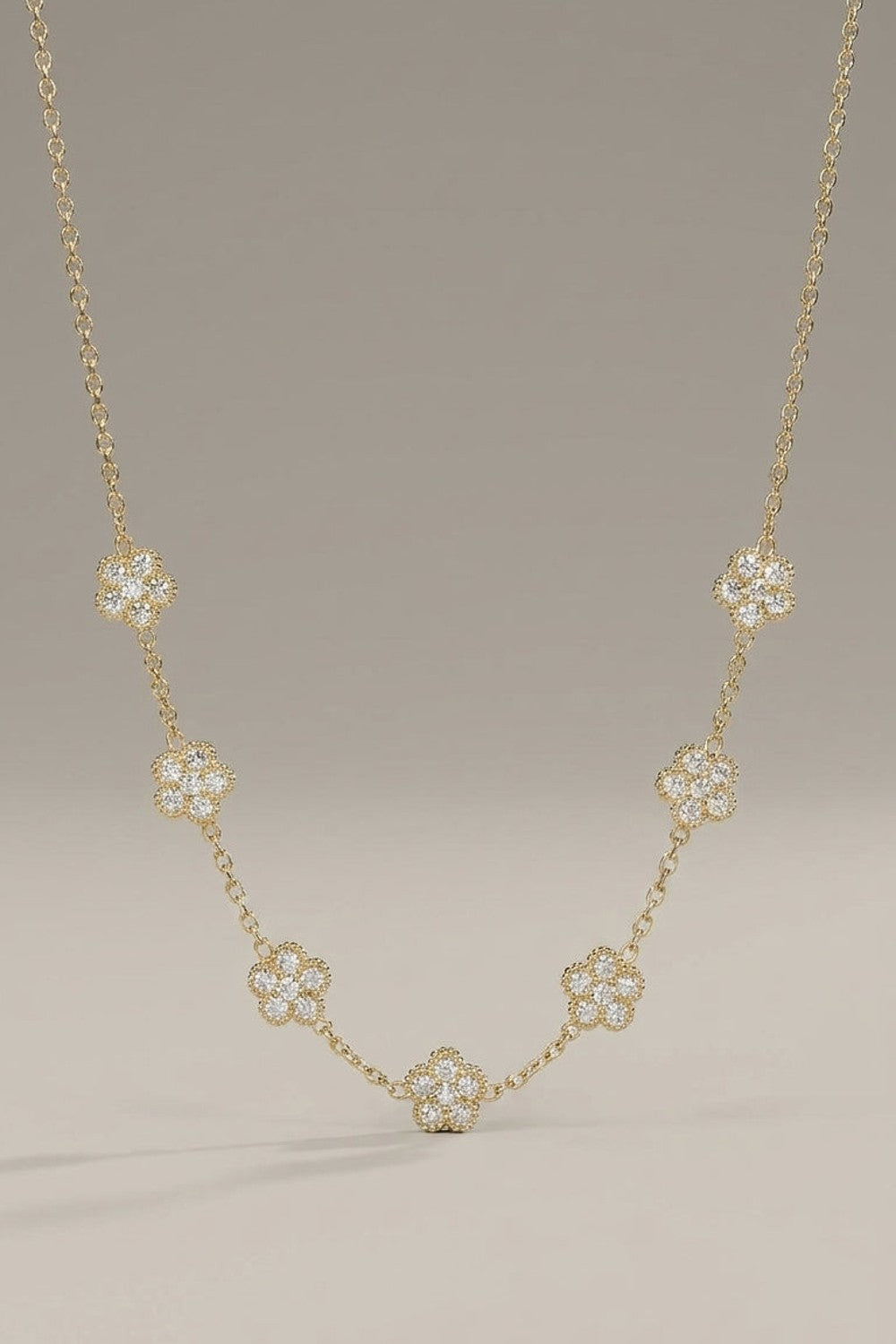 Gold chain necklace featuring seven paved floral zircon stations.