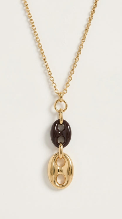 Gold chain necklace with a drop pendant featuring a dark brown link and a polished gold-finish link.