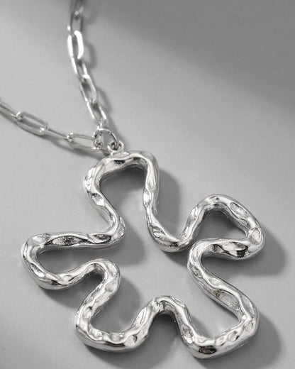 Iconic Lily Flower silver necklace with a textured, abstract floral pendant on a chunky link chain.
