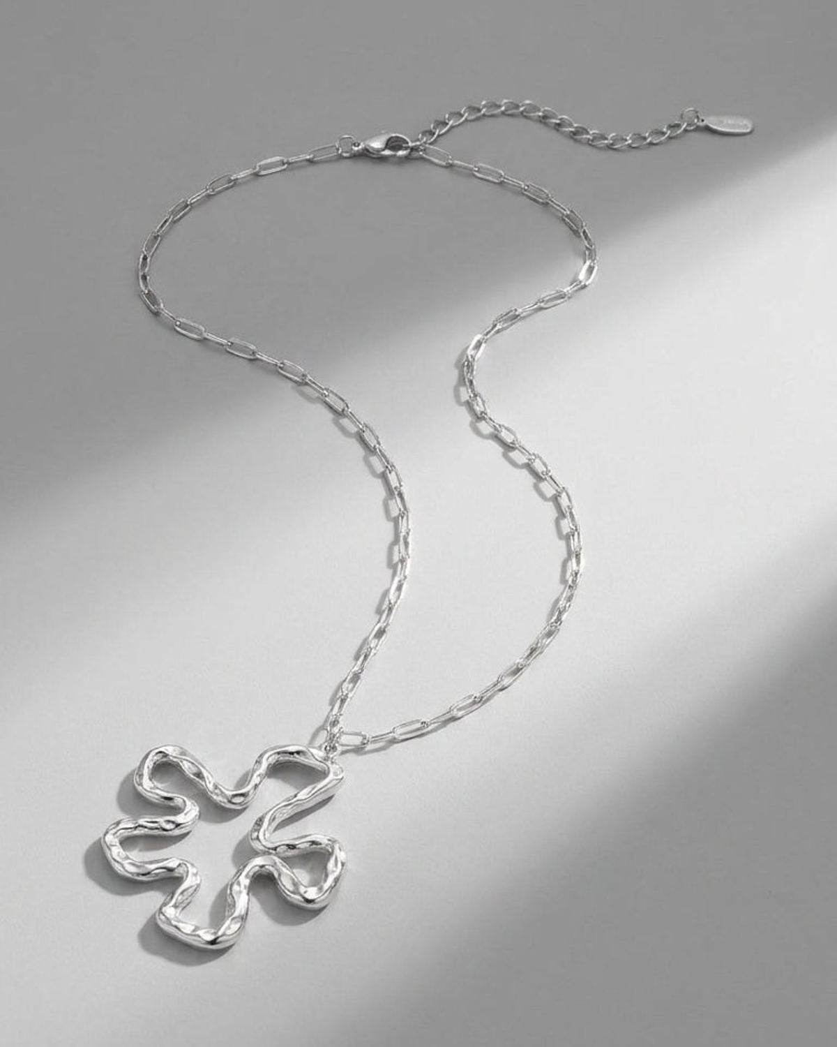 Silver Iconic Lily Flower necklace with a textured, abstract organic flower pendant on a link chain.
