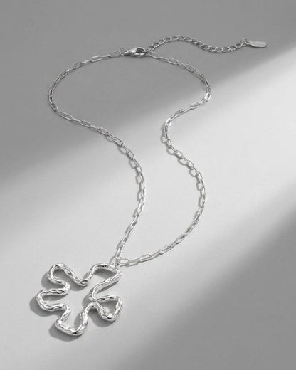 Silver Iconic Lily Flower necklace with a textured, abstract organic flower pendant on a link chain.