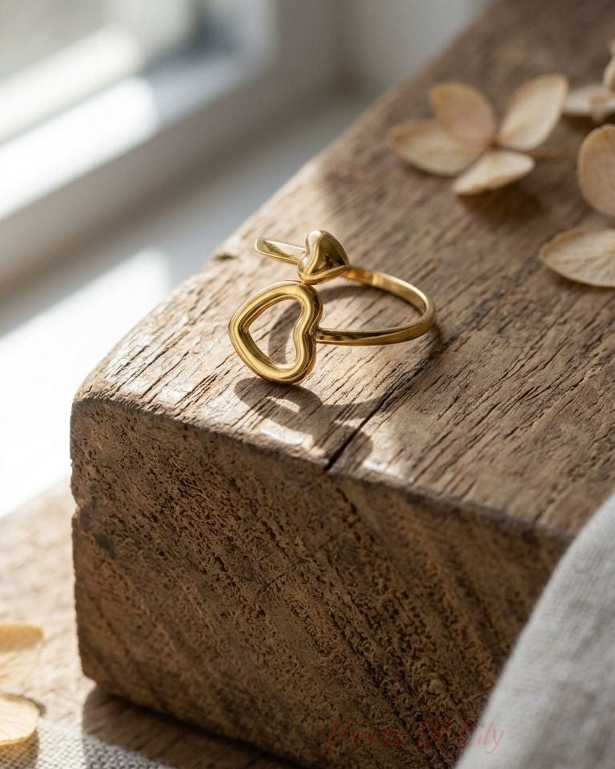 Close-up of the Split Heart Mood ring on a textured wooden surface, highlighting the stainless steel finish and heart pattern.