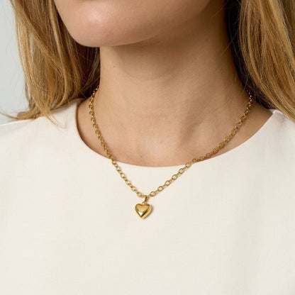 Close-up of the Sweetheart Silver Chain showing a dainty stainless steel heart pendant on textured fabric, highlighting its fine design and sparkle.