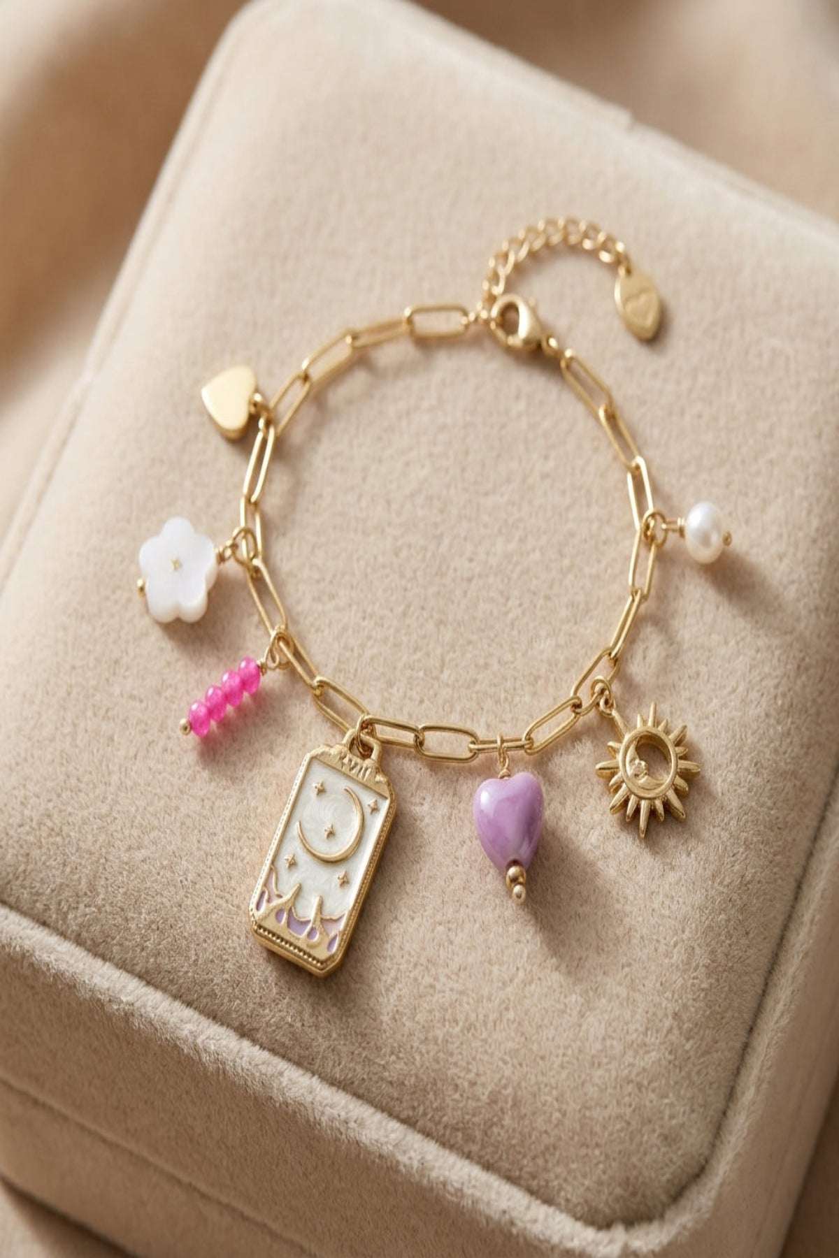 Close-up of a delicate tiny moon charm bracelet in gold or silver on a soft velvet surface with natural lighting