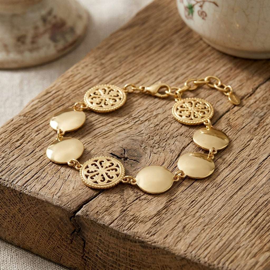 Close-up of stainless steel vintage vibe bracelet with flat coin charms on rustic wood, emphasizing fine details and minimalist design.