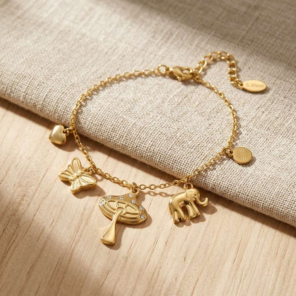 Close-up of the 'Wild Whispers' stainless steel charm bracelet with mushroom, elephant, butterfly, and heart charms, showcasing craftsmanship and rhinestone details.