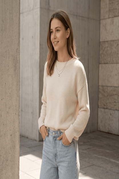 Full-body scene of a young woman wearing the layered heart necklace in a casual urban setting with natural sunlight, showcasing its delicate, feminine style.