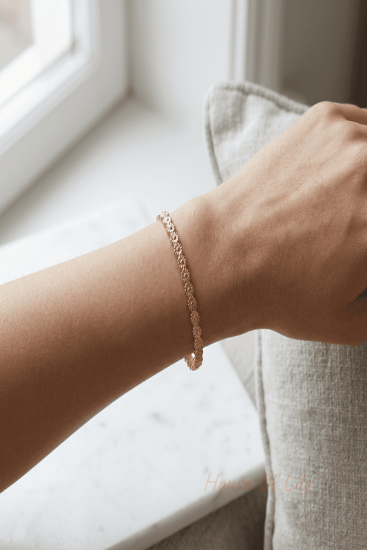 Elegant petite stainless steel floral bangle bracelet on woman's wrist, displayed in a modern softly lit setting emphasizing delicate design.