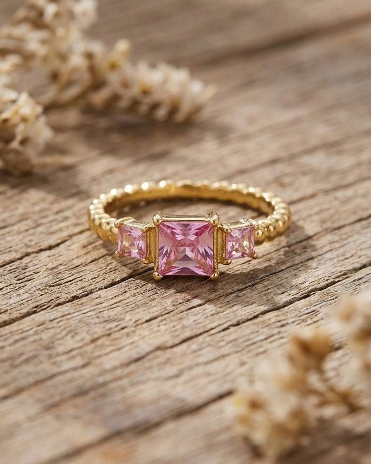 Close-up of Y2K Square Gem gold ring with geometric rectangle shape on rustic wood, illuminated by natural daylight.