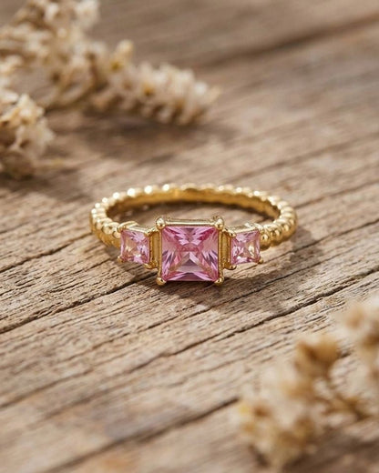 Close-up of Y2K Square Gem gold ring with geometric rectangle shape on rustic wood, illuminated by natural daylight.
